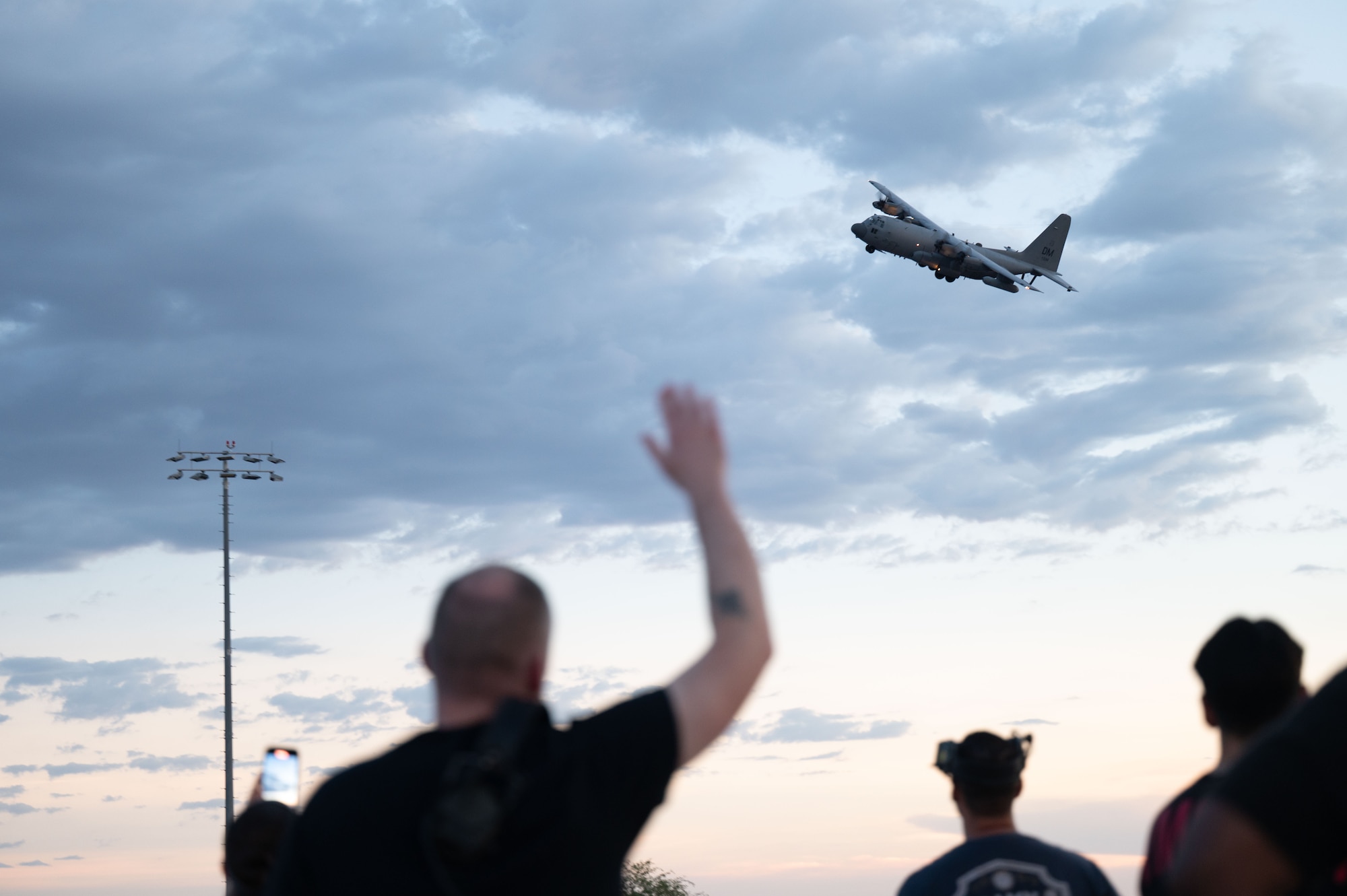 A U.S. Air Force 42nd Electronic Combat Squadron member waves at an EC-130H Compass Call aircraft returning from a contingency deployment at Davis-Monthan Air Force Base, Arizona, August 23, 2025. The 42nd ECS directs EC-130H aircrew initial academic and flying qualification and requalification training for 20 different aircrew specialties with more than 200 aircrew students trained annually. (U.S. Air Force photo by Airman Jaden Kidd)