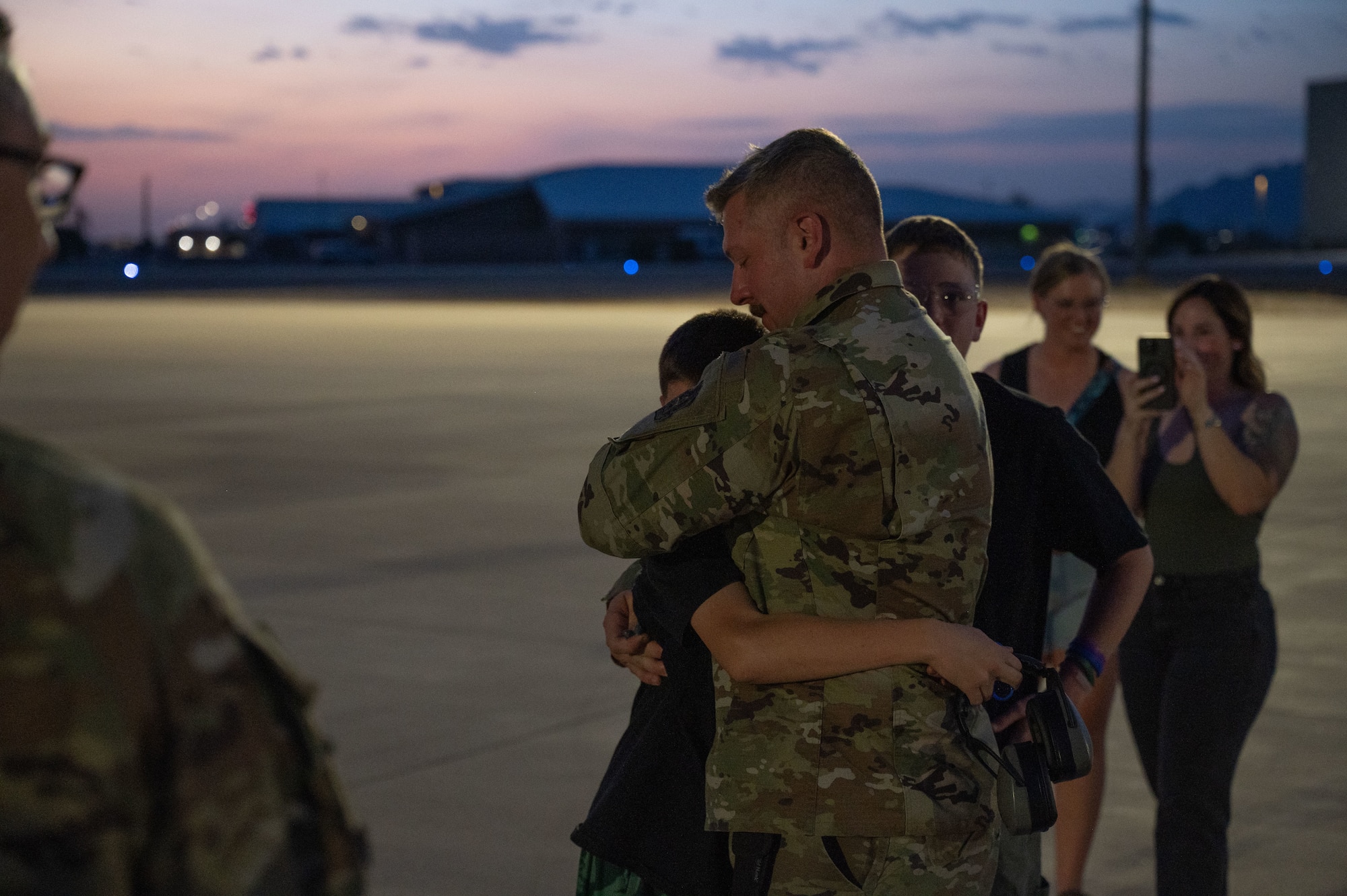 U.S. Air Force Master Sergeant Joshua Geissler, 42nd Electronic Combat Squadron production supervisor, embraces his son after returning from deployment at Davis-Monthan Air Force Base, Arizona, August 23, 2025. The 42nd ECS provides the 55th Electronic Combat Group with combat ready EC-130H Compass Call trained aircrews. (U.S. Air Force photo by Airman Jaden Kidd)