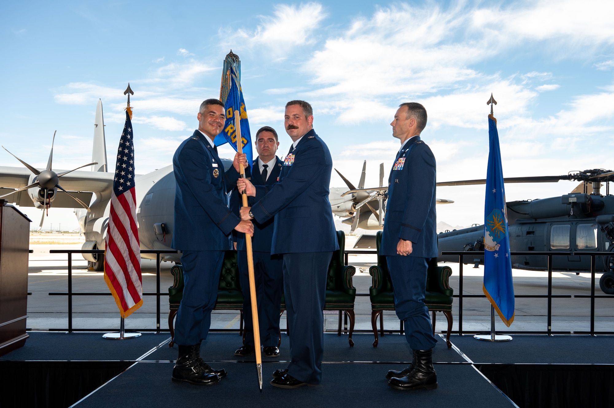 U.S. Air Force Col. Charles Redmond, 563rd Rescue Group outgoing commander, passes the guidon to Col. Jose Cabrera, 355th Wing commander, during the 563rd RQG Change of Command ceremony at Davis-Monthan Air Force Base, Arizona, Aug. 28, 2025. Redmond passed the guidon to symbolize relinquishing command of the 563rd RQG. (U.S. Air Force photo by Senior Airman Jasmyne Bridgers-Matos)