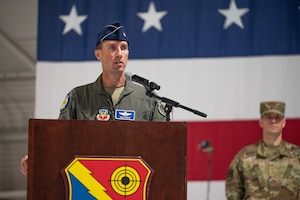 An Airman speaks at a podium.
