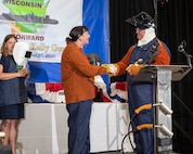 Dr. Kelly Geurts, ship sponsor of the future Columbia-class ballistic missile submarine USS Wisconsin (SSBN 827), left, shakes hands with Robert Ray Jr. after welding her initials in the keel of the ship during the ship’s keel-laying ceremony.
