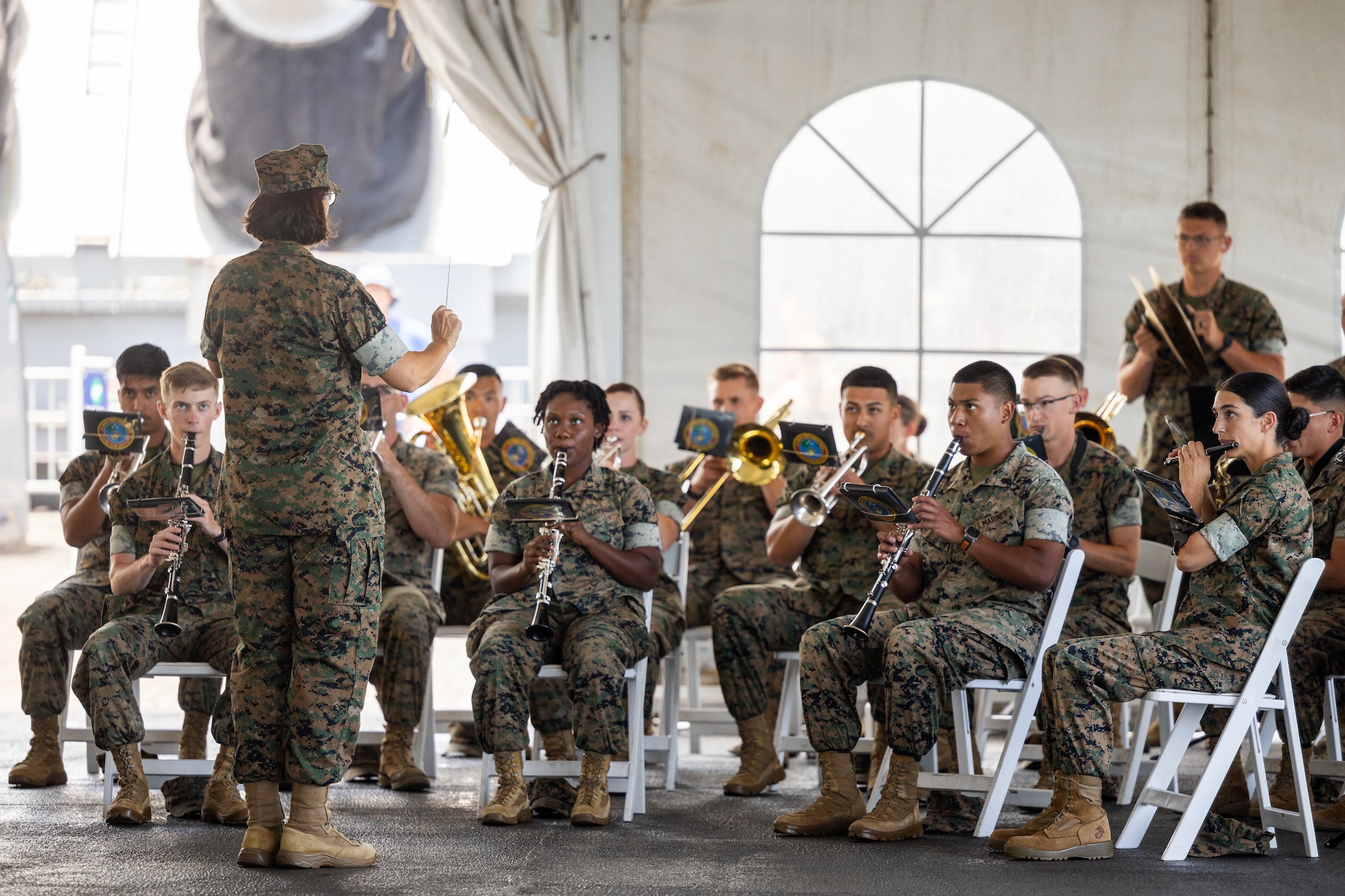 Enlisted Bandleader MSgt Monica Preston conducts the U.S. Marine Corps Forces Pacific Band perform during the MARFORPAC relief and appointment ceremony aboard the Battleship Missouri Memorial, Ford Island, Hawaii, June 23, 2025.