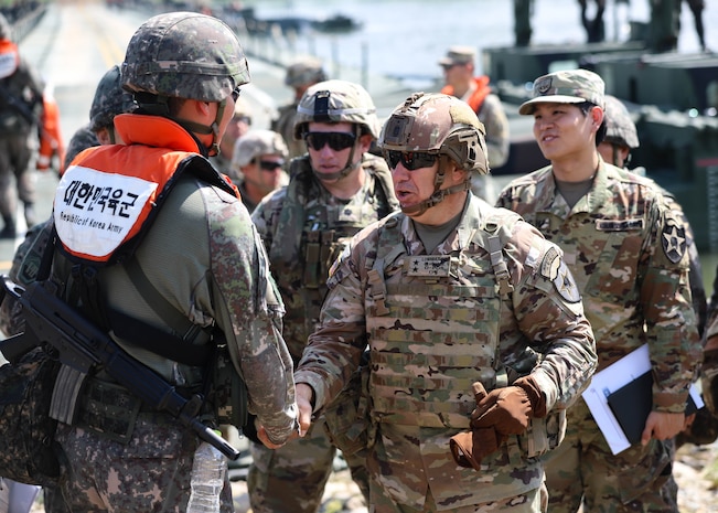 U.S. Army Maj. Gen. Charles Lombardo, commanding general of the 2d Infantry Division/ROK-U.S. Combined Division shakes hands with a Republic of Korea soldier assigned to the ROK 312th Wet Gap Battalion, ROK 7th Engineer Brigade, during combined wet gap crossing training as part of Ulchi Freedom Shield near Yeoju, South Korea, Aug 27, 2025.
