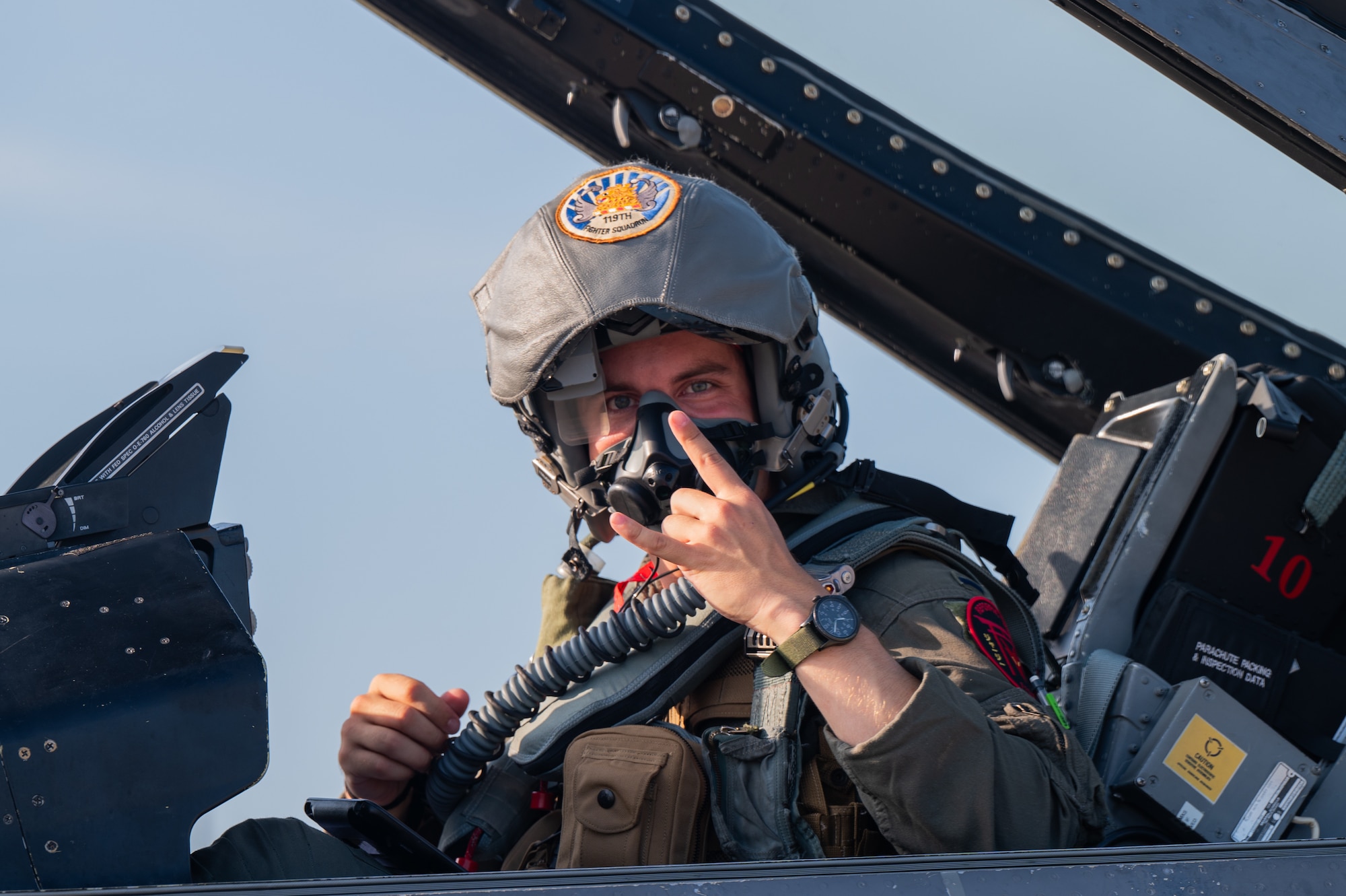 An F-16 Pilot sits in the cockpit of an F-16 fighter jet, preparing for flight.