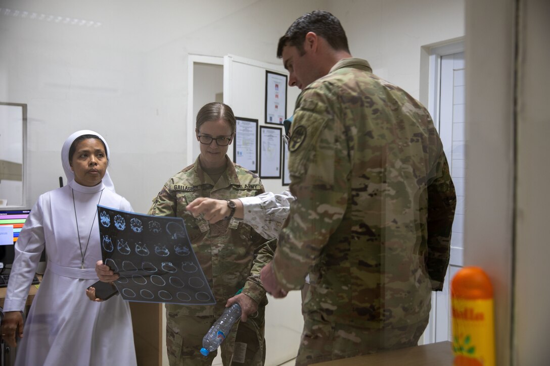 U.S. Army Lt. Col. Maggie Gallagher, a pediatric surgeon from Blanchfield Army Community Hospital, Fort Campbell, Kentucky, and Maj. Thomas Kelley, general surgeon with the 44th Medical Brigade, Womack Army Medical Center, of Ft. Bragg, North Carolina, reviews a CT scan printout at Santo Antonio Hospital in Baturaja, Indonesia, Aug. 26, 2025.