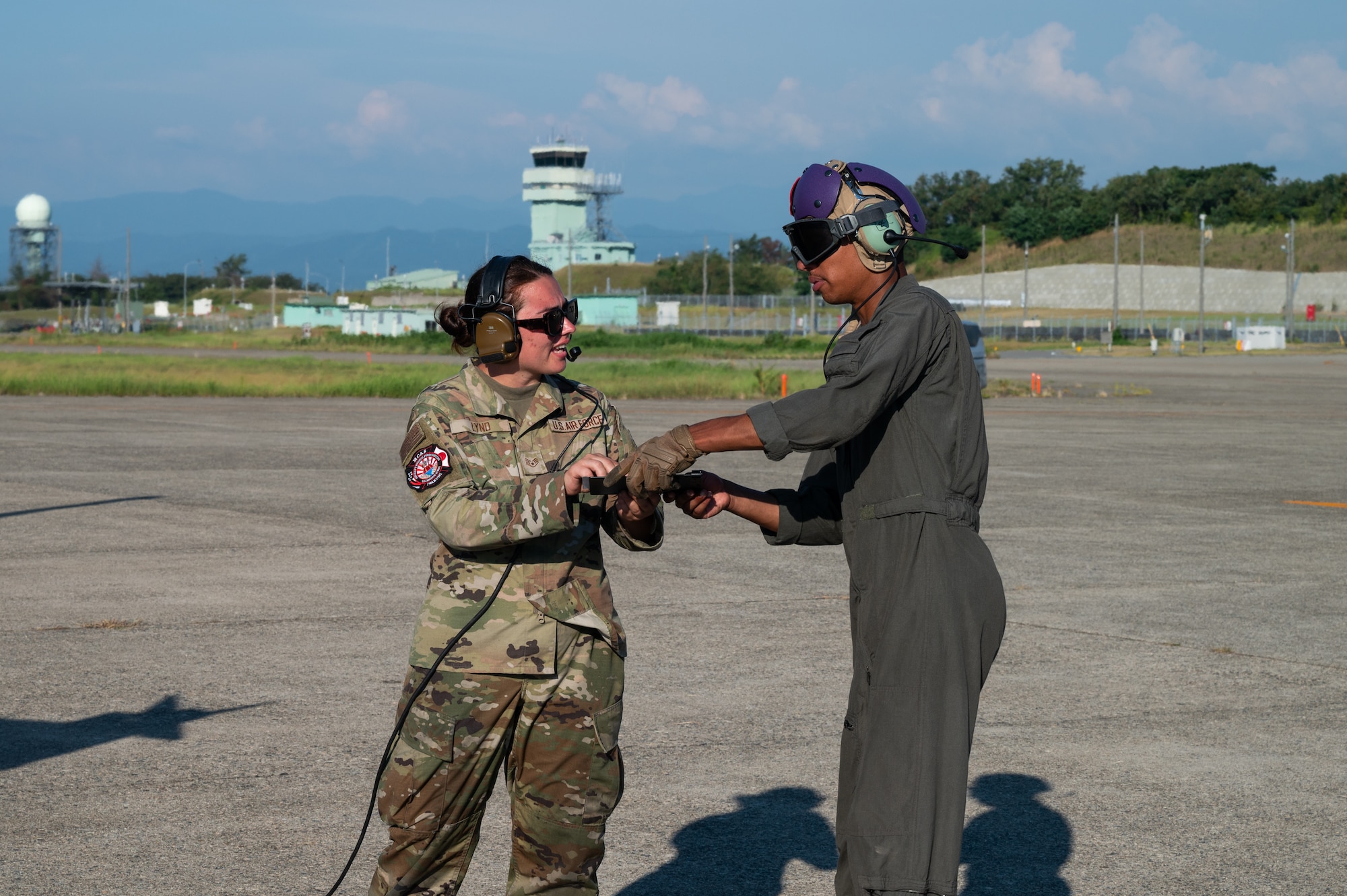 An airman and a Marine complete refueling procedures on an F-16 fighter jet.