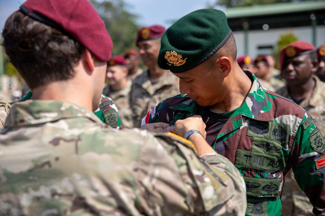 A U.S. Army Soldier assigned to the 1st Special Forces Group (Airborne) pins U.S. Army airborne wings on an Indonesian National Armed Forces paratrooper during a wing exchange ceremony at the Battle Command Training Center in Baturaja, Indonesia, during Super Garuda Shield 25, Aug. 27, 2025.