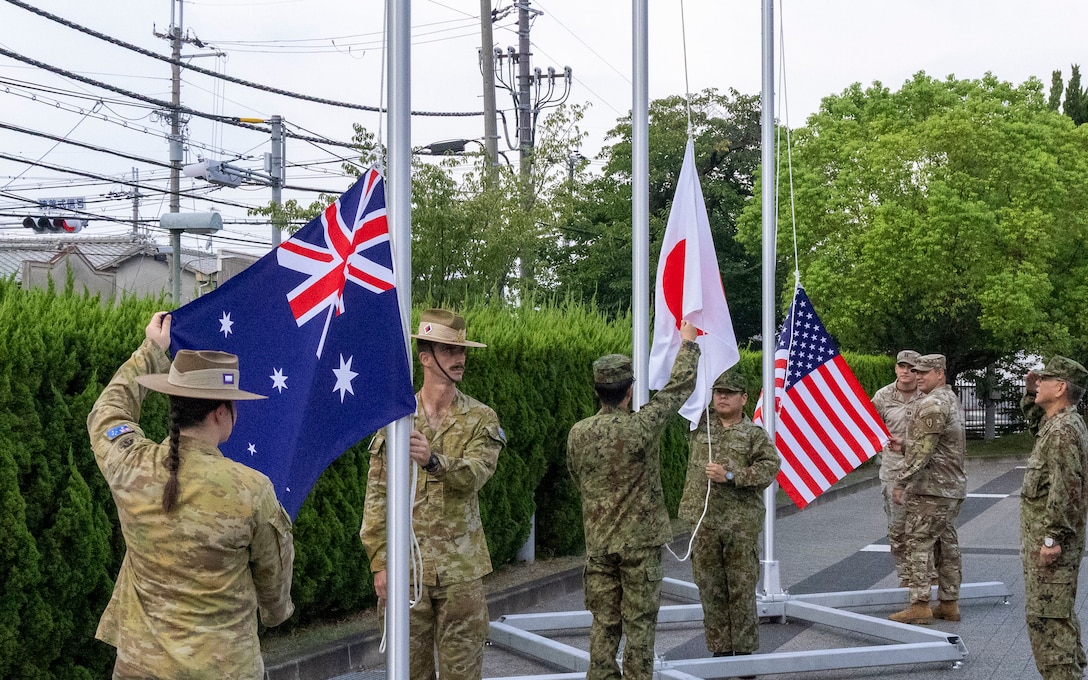Australian Army, Japan Ground Self-Defense Force, and U.S. service members prepare to raise their respective national flags during a ceremonial flag raising at Camp Itami, Japan, Aug. 26,2025