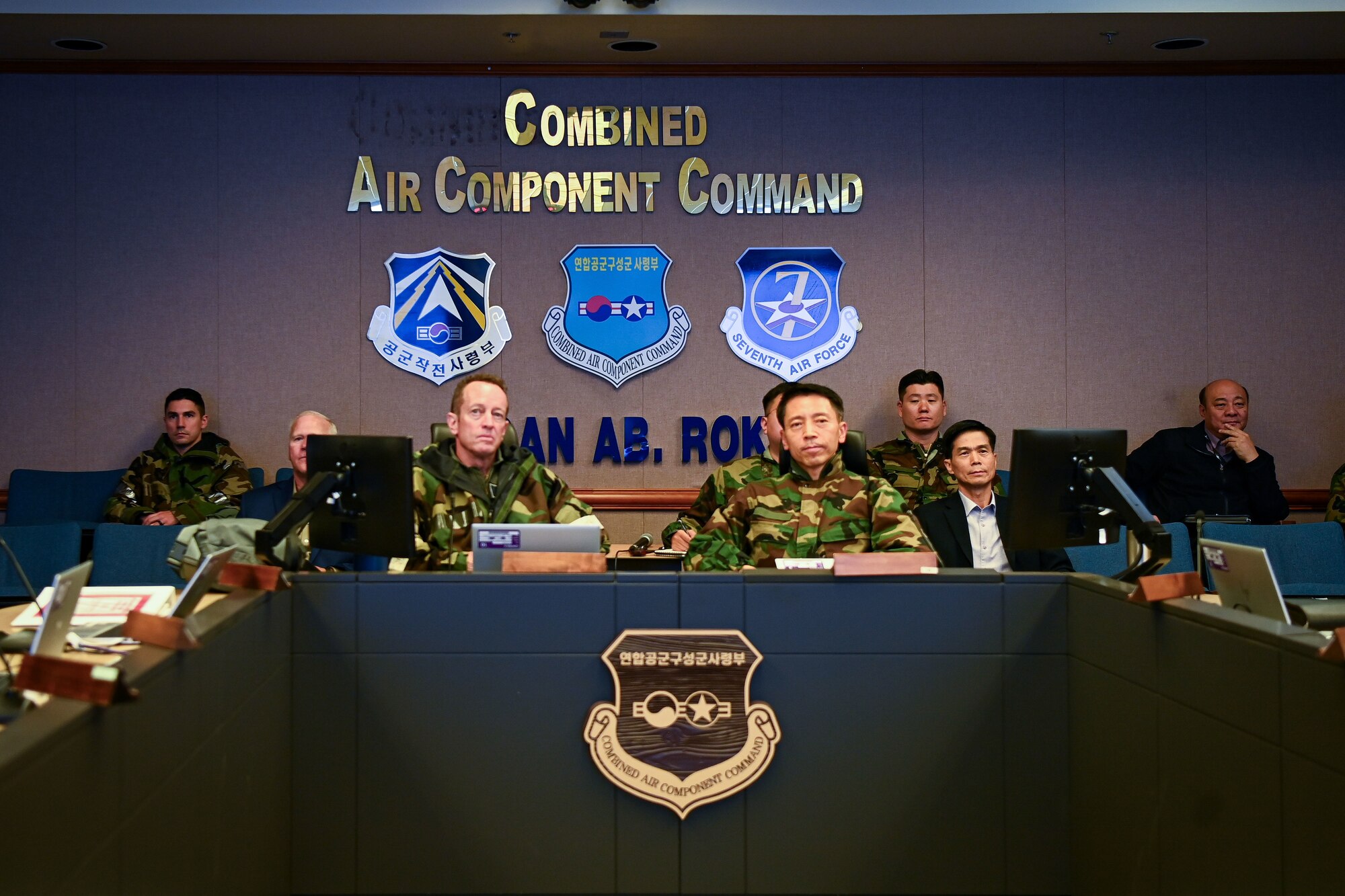 two men sit at conference room table
