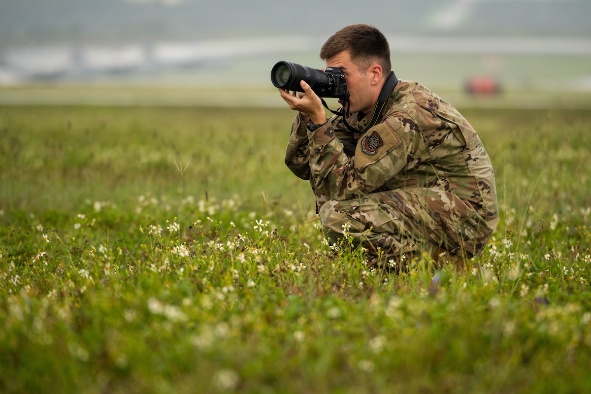 Staff Sgt. Dalton Williams, a Headquarters Air Mobility Command public affairs specialist, photographs aircraft redeploying in support of Exercise Bamboo Eagle 25-3 at Andersen Air Force Base, Guam, July 31, 2025. Public affairs specialists document operations through photography, video and storytelling to highlight mission accomplishments, inform the public and preserve the historical record. (U.S. Air Force photo by Senior Airman Zachary Foster)