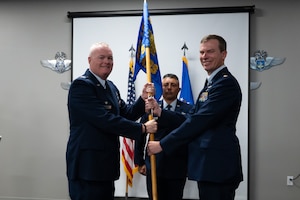 Maj. Daniel Dale (right) is the new commander of the 69th Aerial Port Squadron! Maj. Dale received command during the squadron's change of command ceremony on Aug. 3, 2025, at Joint Base Andrews. Col. Justin Cooper, 759th Logistics Readiness Flight Commander, officiated the ceremony. Maj. Dale comes to the Wing from Peterson Space Force Base, Colo., where he was the Director of Operations for the 39th Aerial Port Squadron. (U.S. Air Force photo by Senior Airman Alexcia Givens)