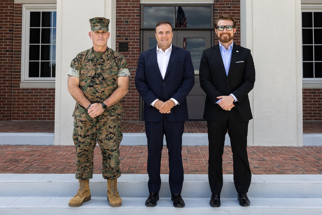 U.S. Marine Corps Brig. Gen. Ralph J. Rizzo, Jr., commanding general, Marine Corps Installations East-Marine Corps Base (MCB) Camp Lejeune, left; Elmer L. Roman, assistant secretary of the Navy for Energy, Installations and Environment, center; and Brandon Wheeler, senior advisor to the Commandant of the Marine Corps, right, pose for a photo following a tour of the future II Marine Expeditionary Force (MEF) headquarters building on MCB Camp Lejeune, North Carolina, Aug. 27, 2025. During his visit, Roman engaged with Marines and their families during a tour of family housing, as well as tours of legacy and modernized barracks facilities and the future II MEF headquarters building. (U.S. Marine Corps photo by Sgt. Yvonna Guyette)