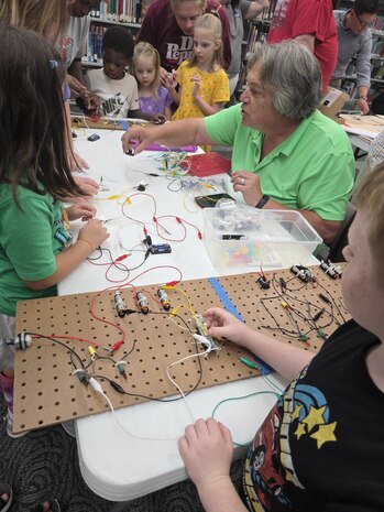Michael Siekkinen, Trident Refit Facility’s STEM coordinator, shows children at the Camden County Library how to build circuits during "Storybook STEM" hosted by the Strategic Weapons Facility Atlantic (SWFLANT) STEM Team.