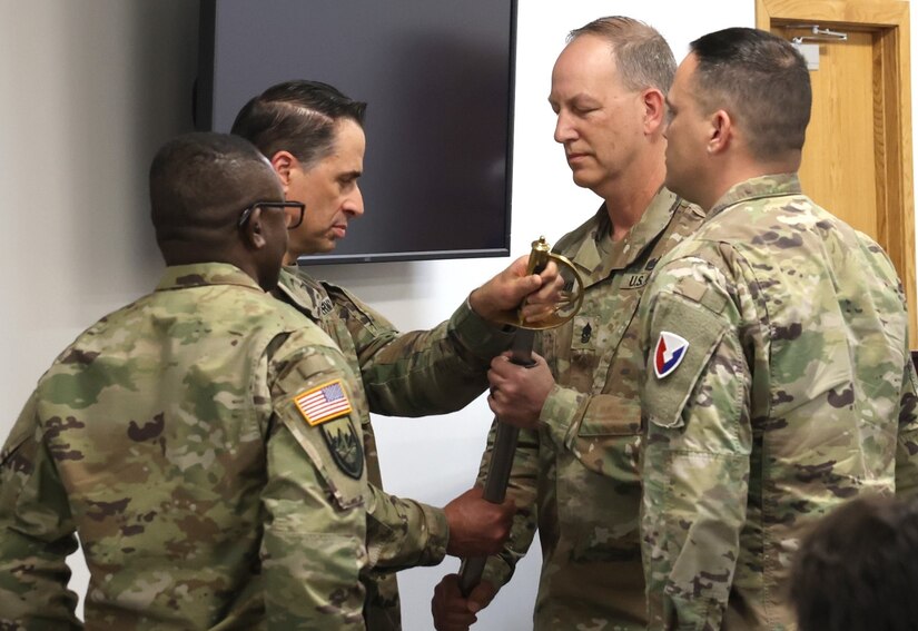 Sgt. Maj. Troy Gearhart, incoming Letterkenny Army Depot sergeant major, accepts the LEAD sword from Col. Donald Santillo, LEAD commander, during a change of responsibility ceremony, March 28, conducted in the depot’s headquarters building.
