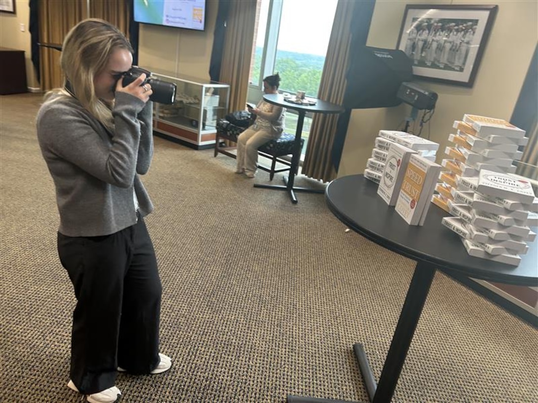Woman standing taking pictures with a camera.