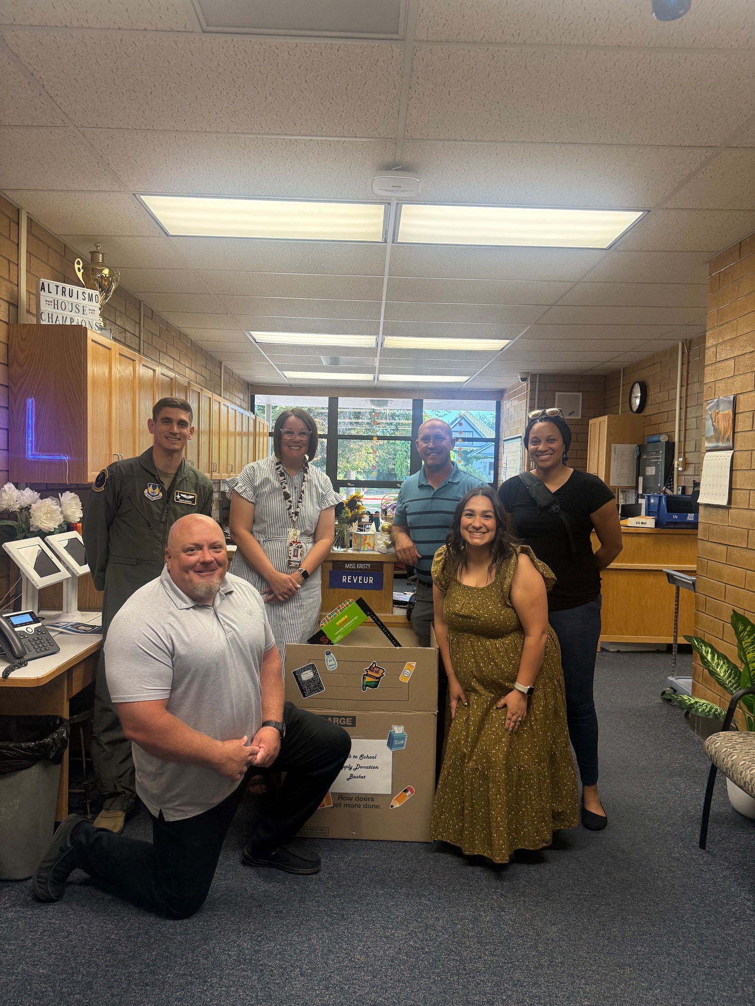 Members of the Arnold Engineering Development Complex 719th Test Squadron at Hill Air Force Base, Utah, deliver school supplies to Layton Elementary in Layton, Utah, Aug. 12, 2025. Members of the 719 TS collected and delivered supplies to two local schools to kick off the 2025-26 school year. Members of the squadron pictured are Intel Project Manager Kyle Romney, kneeling, Director of Intercontinental Ballistic Missile Flight Test Maj. Mike Macchia, left, Safety Engineer Reva Ladd, right, 719 TS Resource Specialist Marissa Gutierrez, second from right, and Technical Management and Advisory Services Group Lead Trevor Foust, third from right. Also pictured is a member of the Layton Elementary staff who accepted the supplies. (Courtesy photo)