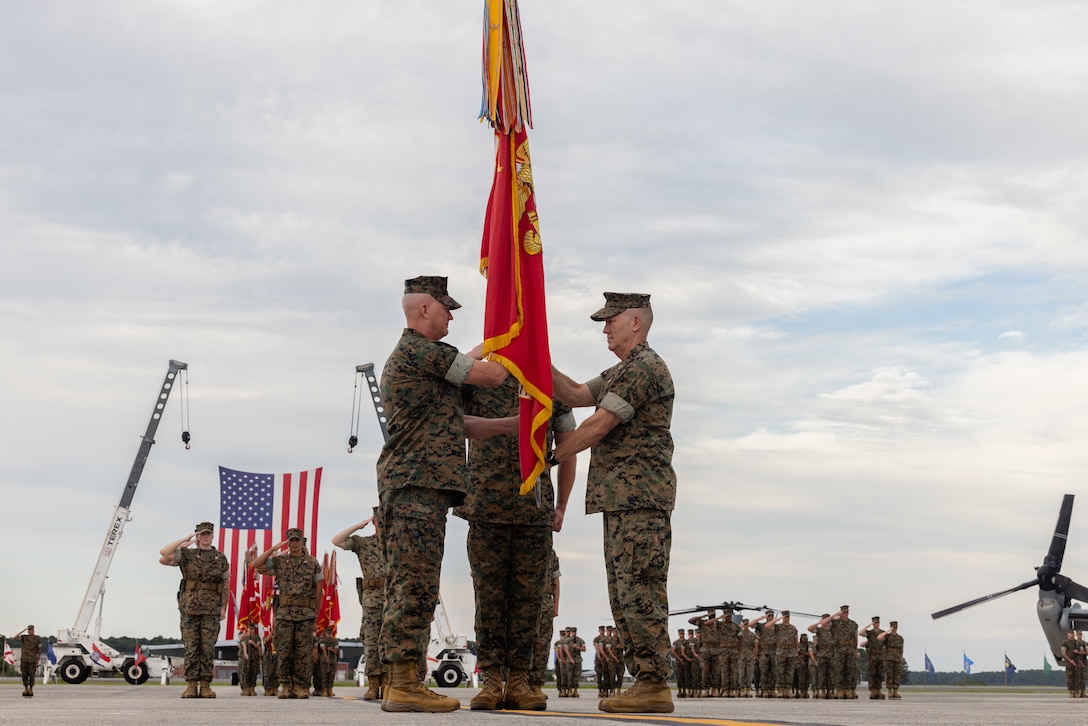 U.S. Marine Corps Maj. Gen. Ryan S. Rideout, left, from Indiana, incoming commanding general, 2nd Marine Aircraft Wing (MAW), receives the colors from Maj. Gen. William H. Swan, from Wisconsin, off-going commanding general, during a change of command ceremony at Marine Corps Air Station Cherry Point, North Carolina, Aug. 28, 2025