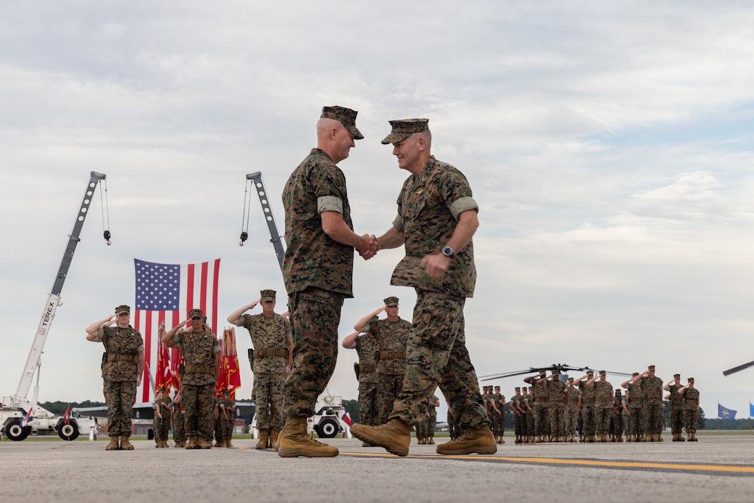 U.S. Marine Corps Maj. Gen. Ryan S. Rideout, left, from Indiana, incoming commanding general, 2nd Marine Aircraft Wing (MAW), and Maj. Gen. William H. Swan, from Wisconsin, outgoing commanding general, shake hands during a change of command ceremony at Marine Corps Air Station Cherry Point, North Carolina, Aug. 28, 2025