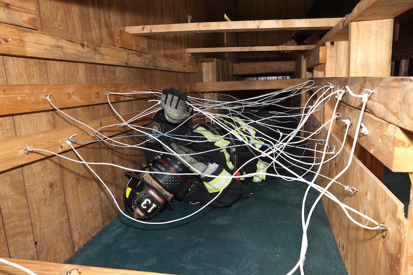 A Letterkenny Army Depot firefighter, wearing a mask that makes him completely blind, works his way through a tangled web of staged wires during firefighter training at the LEAD multi-purpose training facility on May 29.