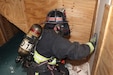 A Letterkenny Army Depot firefighter, wearing a mask that makes him completely blind, navigates his way to a breakthrough wall during firefighter training at the LEAD multi-purpose training facility on May 29.