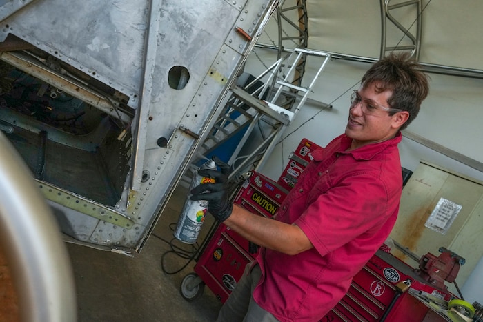 Employee spray painting plane