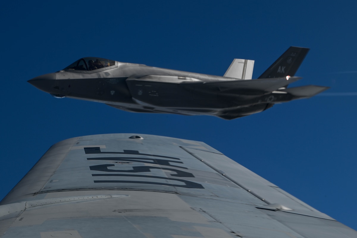 An F-35A Lightning II waits in formation after receiving fuel