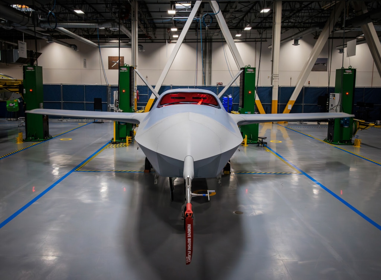 A military airplane is shown in an industrial building.
