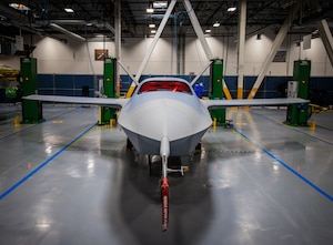 A military airplane is shown in an industrial building.
