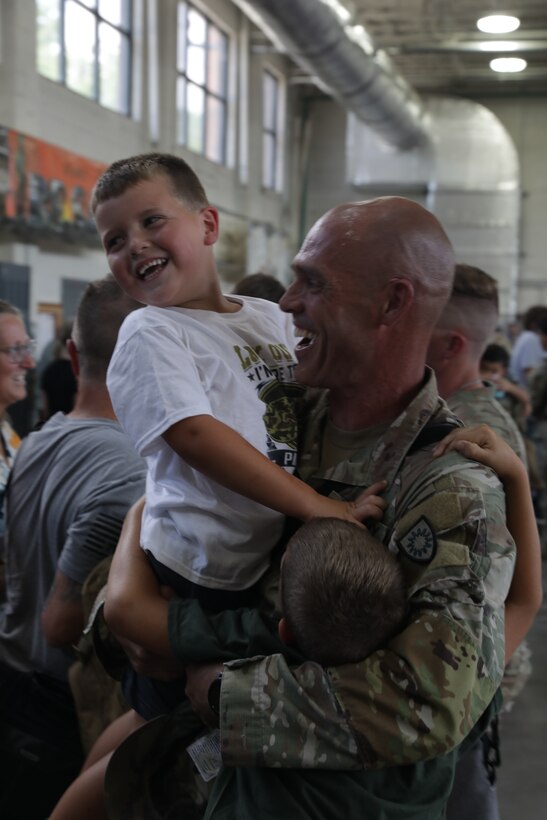 A Soldier from the 223rd Military Police Company embraces his two sons at Buechel Armory, Louisville, Kentucky, Aug. 16, 2025.