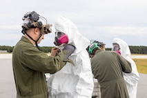 U.S. Marines with Marine Medium Tiltrotor Squadron (VMM) 365, Marine Aircraft Group 26, 2nd Marine Aircraft Wing, put on full-body protective coveralls during an aircraft mishap exercise at Marine Corps Outlying Landing Field Camp Davis on Marine Corps Base Camp Lejeune, North Carolina, Aug. 28, 2025.