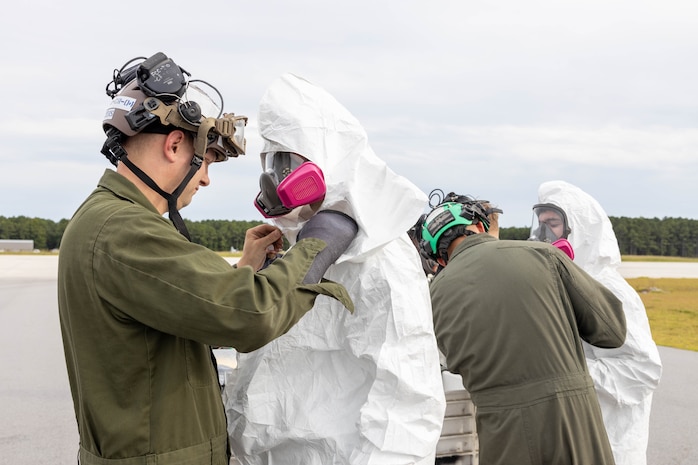 U.S. Marines with Marine Medium Tiltrotor Squadron (VMM) 365, Marine Aircraft Group 26, 2nd Marine Aircraft Wing, put on full-body protective coveralls during an aircraft mishap exercise at Marine Corps Outlying Landing Field Camp Davis on Marine Corps Base Camp Lejeune, North Carolina, Aug. 28, 2025.