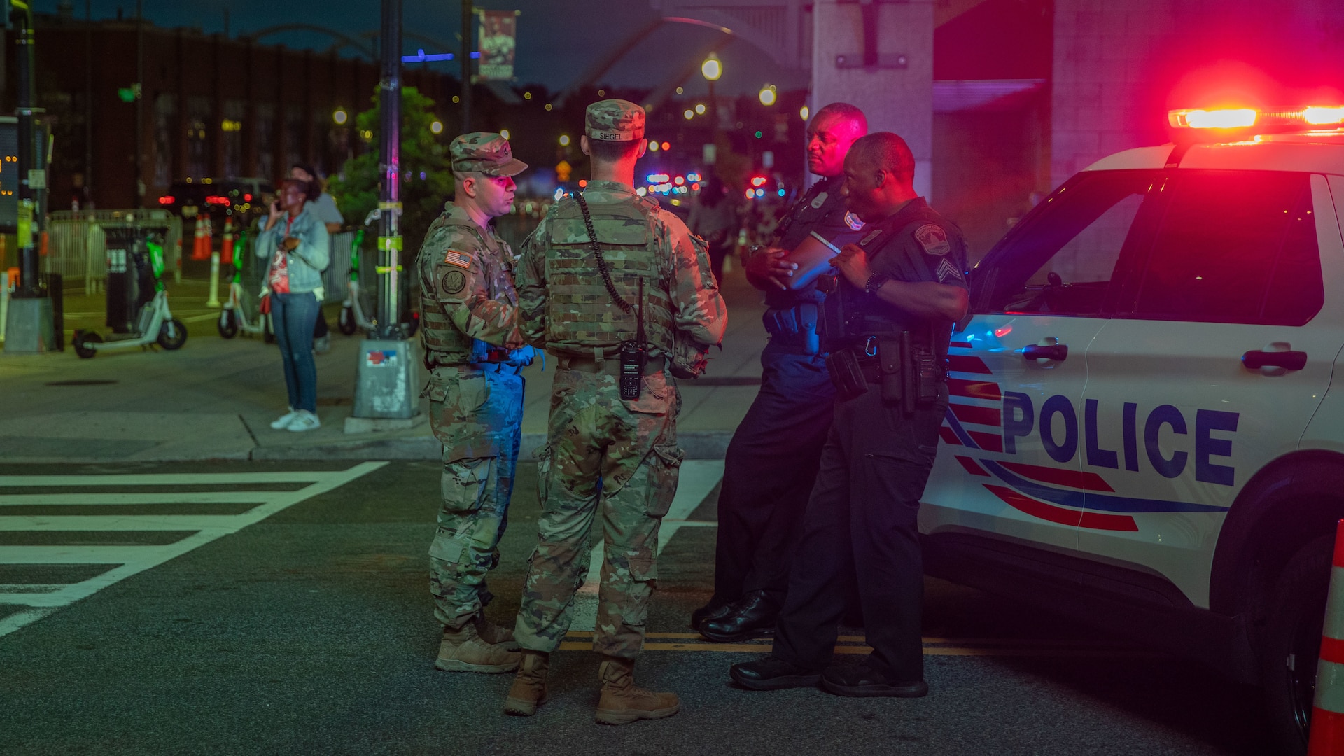 U.S. Army 2nd Lt. Harry Siegel and Sgt. 1st Class Nikolay Bashko talk with Metropolitan Police Department officers near Nationals Park, Aug. 19, 2025. The D.C. National Guard is uniquely commanded by the President of the United States through the Secretary of Defense. Guard members were activated under the Joint Task Force–District of Columbia as part of the D.C. Safe and Beautiful Task Force to support District and federal partners in safeguarding property and ensuring the functions of government.