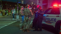 U.S. Army 2nd Lt. Harry Siegel and Sgt. 1st Class Nikolay Bashko talk with Metropolitan Police Department officers near Nationals Park, Aug. 19, 2025. The D.C. National Guard is uniquely commanded by the President of the United States through the Secretary of Defense. Guard members were activated under the Joint Task Force–District of Columbia as part of the D.C. Safe and Beautiful Task Force to support District and federal partners in safeguarding property and ensuring the functions of government.