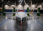 A military airplane is shown in an industrial building.
