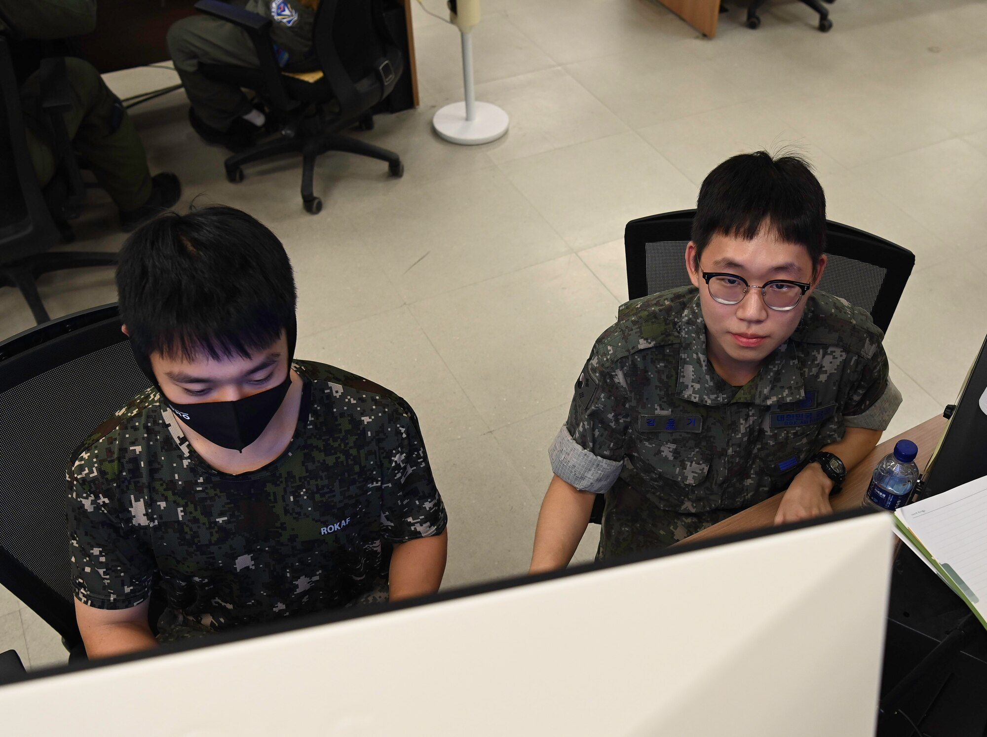 Two people sit in front of a computer.