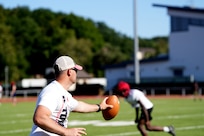 Sgt. 1st Class Stephen Burkham, an Army medic, coaches defensive backs during a Kaiserslautern High School football practice in Kaiserslautern, Germany. Burkham volunteers as both a coach and medic, and last fall helped save a player’s life during a game.