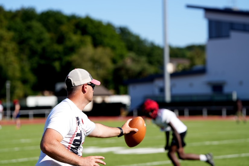 Sgt. 1st Class Stephen Burkham, an Army medic, coaches defensive backs during a Kaiserslautern High School football practice in Kaiserslautern, Germany. Burkham volunteers as both a coach and medic, and last fall helped save a player’s life during a game.