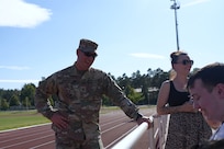 Staff Sgt. Stephen Burkham, an Army medic with the 7th Mission Support Command, talks with Kaiserslautern High School athletes and families during football practice in Kaiserslautern, Germany. Burkham, along with Lt. Col. Juanita Dubon, was recognized for providing lifesaving aid to a player last fall.