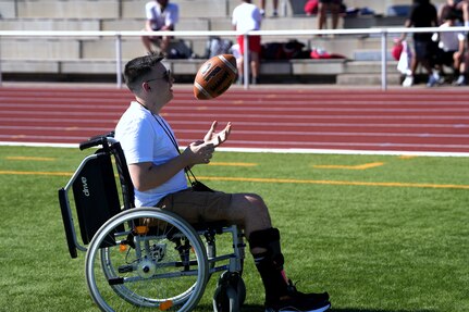 Kaiserslautern High School student Aiden, center, sits with his family and Staff Sgt. Stephen Burkham, right, and Lt. Col. Juanita Dubo, top, after returning to the football field months after a medical emergency during a game. Burkham and Dubon, both Army Reserve Soldiers, are credited with saving Aiden’s life through their volunteer medical support.