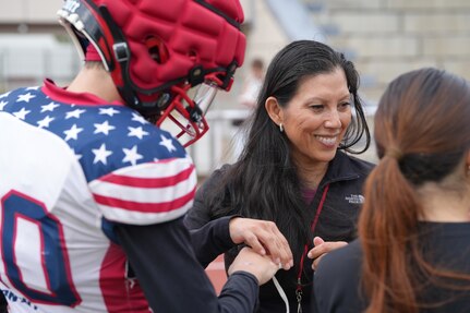 Lt. Col. Juanita Dubon, an Army nurse practitioner, volunteers with Kaiserslautern High School athletes during a football practice in Kaiserslautern, Germany. Dubon, along with Staff Sgt. Stephen Burkham, is credited with saving a student’s life during a game last fall.