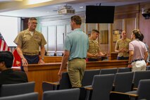 U.S. Marine Corps Col. Iain Pedden, left, a judge advocate and the director of Appellate Government Division, Mavy and Marine Corps Criminal Court of Appeals, Maj. Lambert Jackson, center, a deputy staff judge advocate with the Judge Advocate Division of Headquarters Marine Corps, and Maj. Courtney Thompson, right, the commanding officer for Recruiting Station Boston, 1st Marine Corps District, discuss the Marine Corps judge advocate program with law students at Suffolk University Law School during Marine Week Boston, Aug. 25, 2025. During Marine Week Boston, Marines with Marine Corps Recruiting Command shared Marine Corps traditions and opportunities with the local community. (U.S. Marine Corps photo by Sgt. Aidan Hekker)