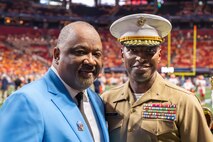U.S. Marine Corps Brig. Gen. Ahmed T. Williamson (right), the commanding general of Marine Corps Recruit Depot Parris Island and Eastern Recruiting Region, assigned to Special Purpose Marine Air-Ground Task Force-250, and Virgil Miller (left), president of Aflac, pose for a photo at a football game during Marine Week Atlanta, Aug. 30, 2025. Marines stationed across the globe commemorate the 250th anniversary of the Marine Corps, honoring a distinguished legacy of service, sacrifice, and unwavering fidelity to both the nation and fellow Marines. (U.S. Marine Corps photo by Cpl. Samantha Pollich)