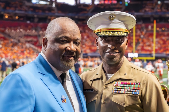 U.S. Marine Corps Brig. Gen. Ahmed T. Williamson (right), the commanding general of Marine Corps Recruit Depot Parris Island and Eastern Recruiting Region, assigned to Special Purpose Marine Air-Ground Task Force-250, and Virgil Miller (left), president of Aflac, pose for a photo at a football game during Marine Week Atlanta, Aug. 30, 2025. Marines stationed across the globe commemorate the 250th anniversary of the Marine Corps, honoring a distinguished legacy of service, sacrifice, and unwavering fidelity to both the nation and fellow Marines. (U.S. Marine Corps photo by Cpl. Samantha Pollich)