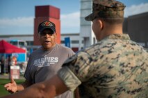 A retired civilian interacts with Marines at Centennial Olympic Park in Atlanta, Georgia during Marine Week Atlanta, Aug. 30, 2025. Marines stationed across the globe commemorate the 250th anniversary of the Marine Corps, honoring a distinguished legacy of service, sacrifice, and unwavering fidelity to both the nation and the Corps. (U.S. Marine Corps photo by Sgt. Alexis French)