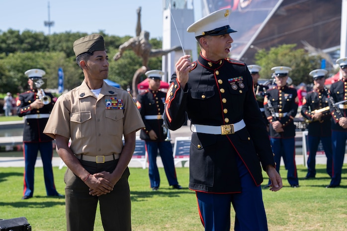 U.S. Marine Corps Sgt. Taylor Brown, right, a musician with the 2D Marine Aircraft Wing Band, assigned to Special Purpose Marine Air-Ground Task Force-250, allows a member of the Young Marines to experience conducting the band during Marine Week Atlanta, Aug. 31, 2025. Marines stationed across the globe commemorate the 250th anniversary of the Marine Corps, honoring a distinguished legacy of service, sacrifice, and unwavering fidelity to both the nation and fellow Marines. (U.S. Marine Corps photo by Sgt. Alfonso Livrieri)