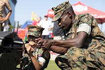 A U.S. Marine assigned to Special Purpose Marine Air-Ground Task Force-250, interacts with a member of the Young Marines Program during Marine Week Atlanta, Aug. 31, 2025. Marines stationed across the globe commemorate the 250th anniversary of the Marine Corps, honoring a distinguished legacy of service, sacrifice, and unwavering fidelity to both the nation and fellow Marines. (U.S. Marine Corps photo by Lance Cpl. Kiara Rawls)