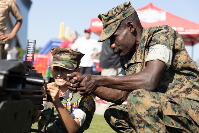A U.S. Marine assigned to Special Purpose Marine Air-Ground Task Force-250, interacts with a member of the Young Marines Program during Marine Week Atlanta, Aug. 31, 2025. Marines stationed across the globe commemorate the 250th anniversary of the Marine Corps, honoring a distinguished legacy of service, sacrifice, and unwavering fidelity to both the nation and fellow Marines. (U.S. Marine Corps photo by Lance Cpl. Kiara Rawls)