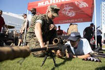 A U.S. Marine assigned to Special Purpose Marine Air-Ground Task Force-250, interacts with an attendee during Marine Week Atlanta, Aug. 31, 2025. Marines stationed across the globe commemorate the 250th anniversary of the Marine Corps, honoring a distinguished legacy of service, sacrifice, and unwavering fidelity to both the nation and fellow Marines. (U.S. Marine Corps photo by Lance Cpl. Kiara Rawls)