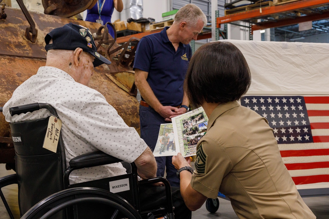U.S. Marine Corps veteran Cpl. Leighton Willhite, who served in the Battle of Iwo Jima, left, looks at pictures of the tank after it was recovered with Master Gunnery Sgt. Lisa Marshall, senior career counselor with Manpower and Reserve Affairs, at the Museum Support Facility in Dumfries, Virginia.