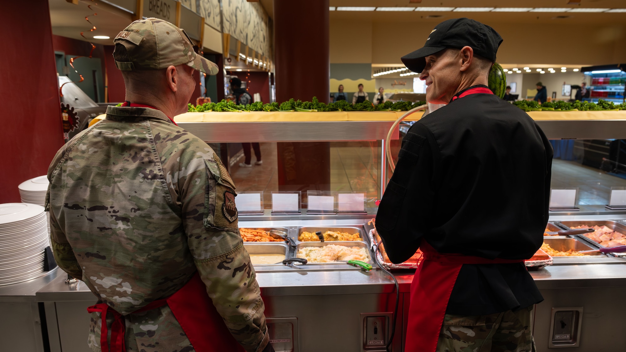 U.S. Air Force Col. Ryan Ley, right, 51st Fighter Wing commander, and Col. Kevin Walsh, right, 51st FW deputy commander, share a moment together during a Thanksgiving meal at Osan Air Base, Republic of Korea, Nov. 27, 2025. The event reflected the importance of community, support, and leadership visibility. (U.S. Air Force photo by Senior Airman Rome Bowermaster)